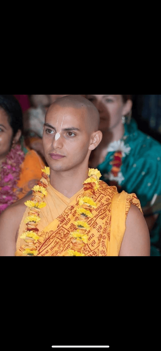 Madhu in saffron robes with a flower garland
